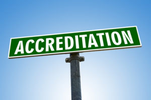 accreditation word on green road sign