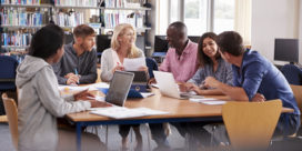 a group of college students studying in the library