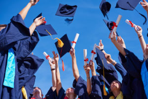 a group of graduates tossing their caps in the air
