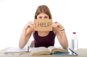 College student with a handwritten "help" sign on her head