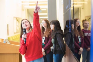 A girl with a microphone leading a group of others