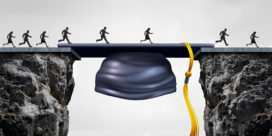 People crossing a bridge that is made out of a graduation cap