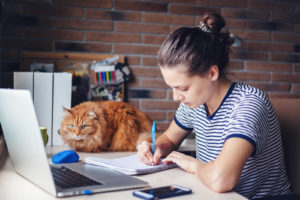 A woman works at home as she is pursuing higher education.