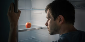 A man peers into the fridge and sees only an apple. A new report details the variables that influence how food insecurity can fluctuate for many college students.