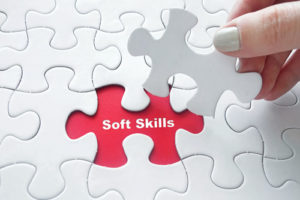 A hand holds a puzzle piece above the word "soft skills," demonstrating how essential they are for a complete education.