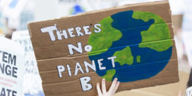 Climate change presents education with an opportunity to focus on problem solving and critical thinking, like this climate change protester holding a sign.