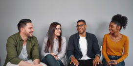 Four students sit in chairs talking, a sign that they feel connected on campus.