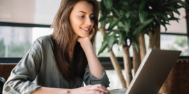 This smiling college student is taking an online course.