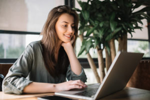 This smiling college student is taking an online course.