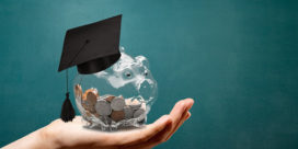 This hand holding a piggy bank with college savings demonstrates how higher education is under scrutiny.