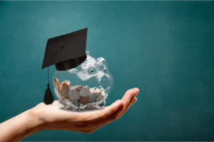 This hand holding a piggy bank with college savings demonstrates how higher education is under scrutiny.