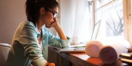 Research shows students struggle with mental health but don't always seek out on-campus counseling--why? This girl sitting at her computer is worried.