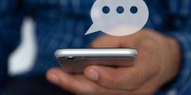 Institutions need new ways to reach students and stakeholders—and SMS text marketing might be the answer to communication problems, like this man's hand texting on a smartphone.