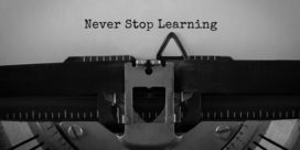 A typewriter with the words Never Stop Learning typed on a piece of paper demonstrates lifelong learning.