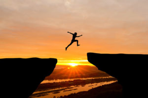 College Explorer, a free interactive tool, help students and their parents realize their potential for higher education, like this person jumping over a gap between two ledges.