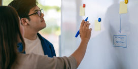 A Berkeley College professor relies on five key elements that, when used together, target student engagement, like these people using teamwork at a whiteboard.